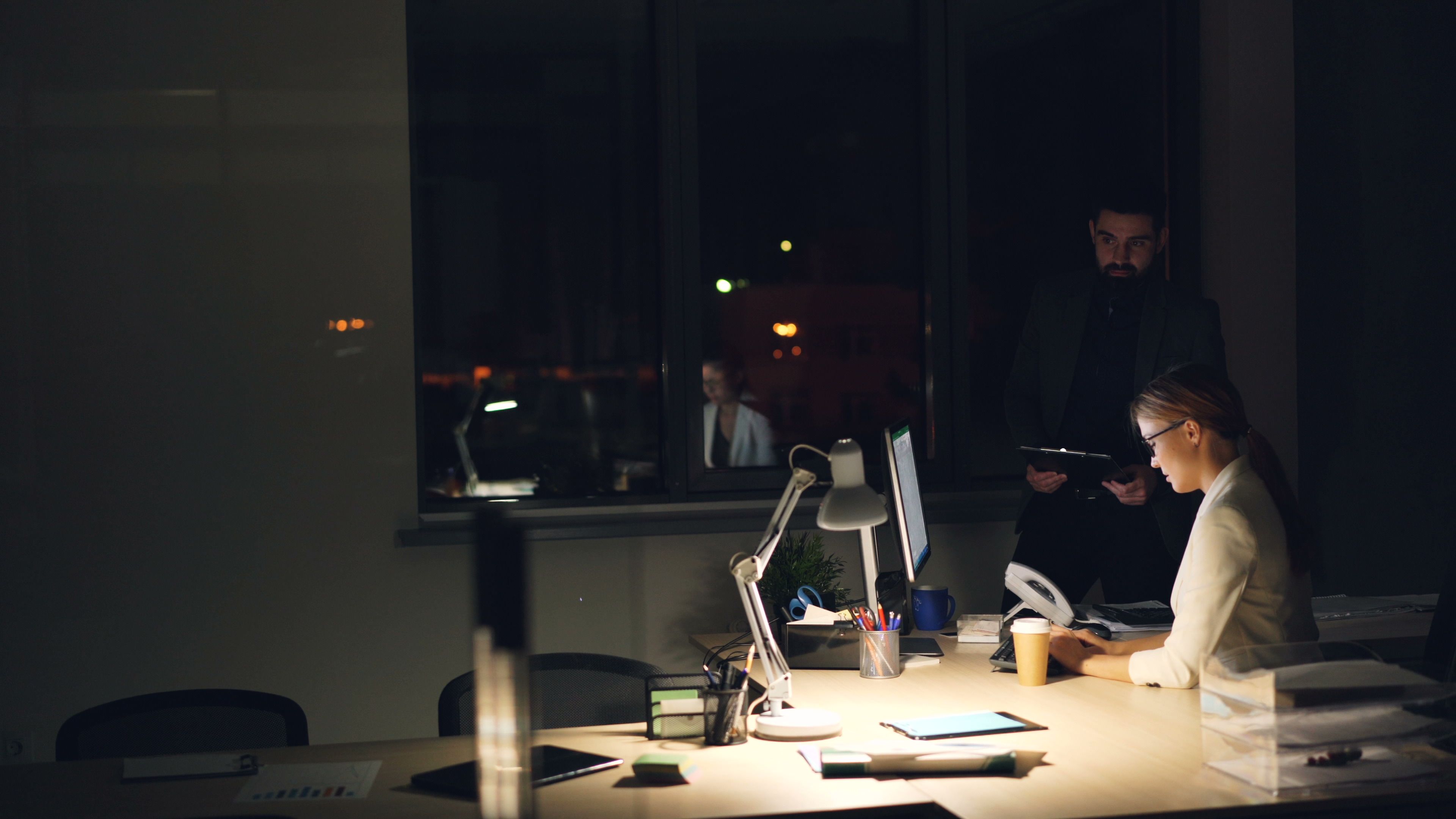 Dark office interior with desk and ambient light